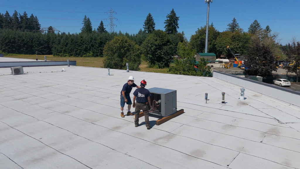 Arctic technician performing commercial HVAC maintenance on rooftop unit
